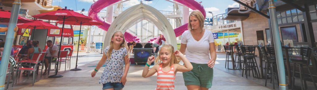 Famiglia che passeggia nella Promenade di una crociera Royal Caribbean